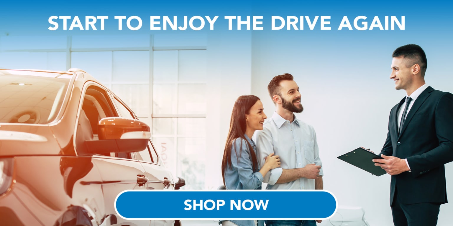 A well-dressed car salesman chatting with a couple in front of a vehicle, with a "Shop Now" button below and the text "START TO ENJOY THE DRIVE AGAIN" above.