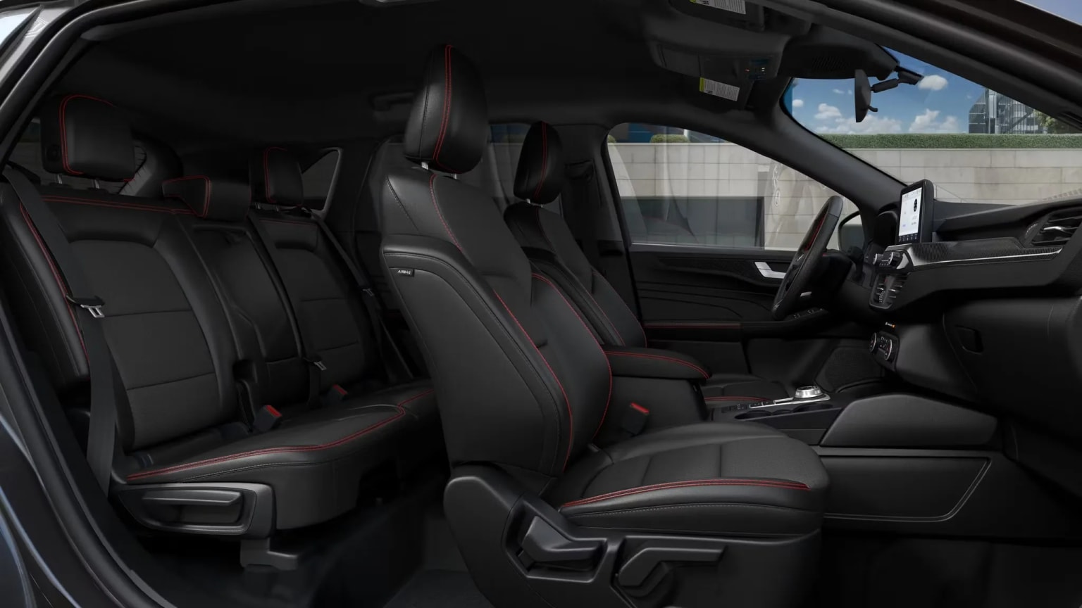 Interior of a vehicle with rows of black leather seats and dashboard visible in the background.