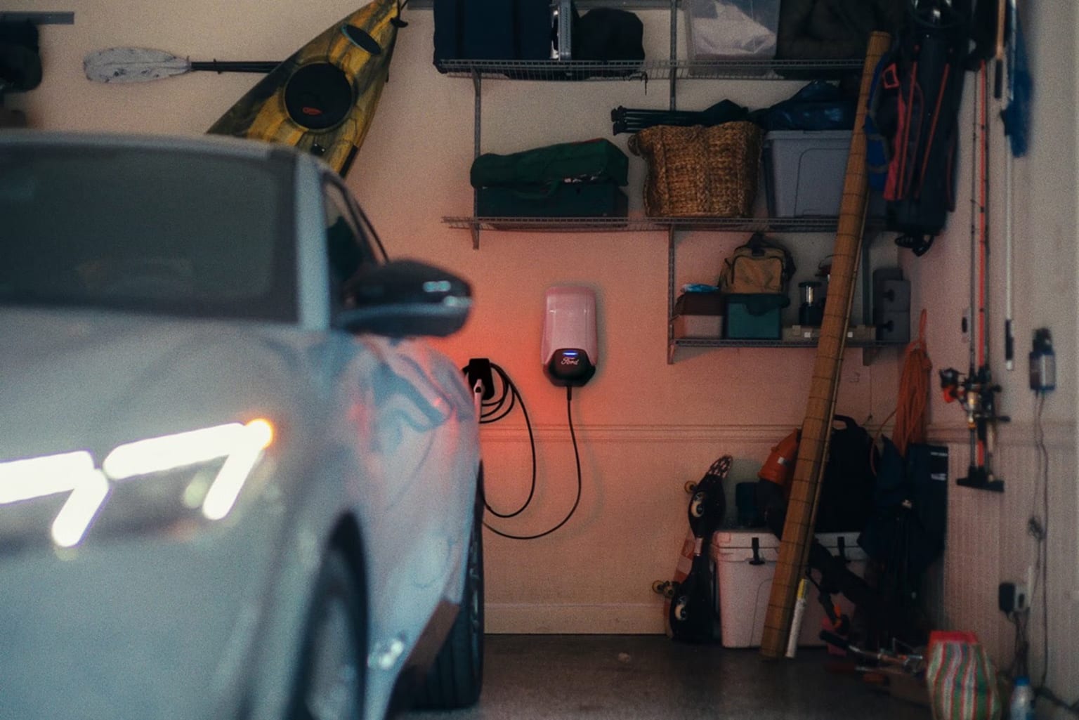 A cluttered garage or storage space with a variety of items, including a car, shelves, and various tools and equipment.