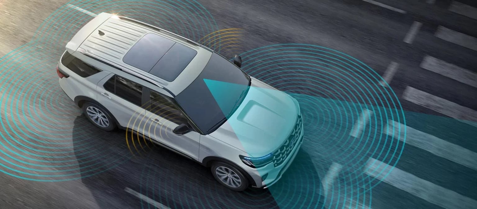 A white and teal-colored 2025 Ford Explorer with various sensors and radar systems visible, surrounded by a network of concentric circles representing the vehicle's detection and monitoring capabilities, against a dark background.