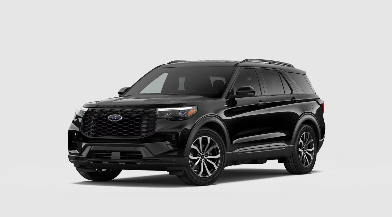 A large, black SUV with a bold, angular design and prominent grille stands prominently against a plain, light-colored background.