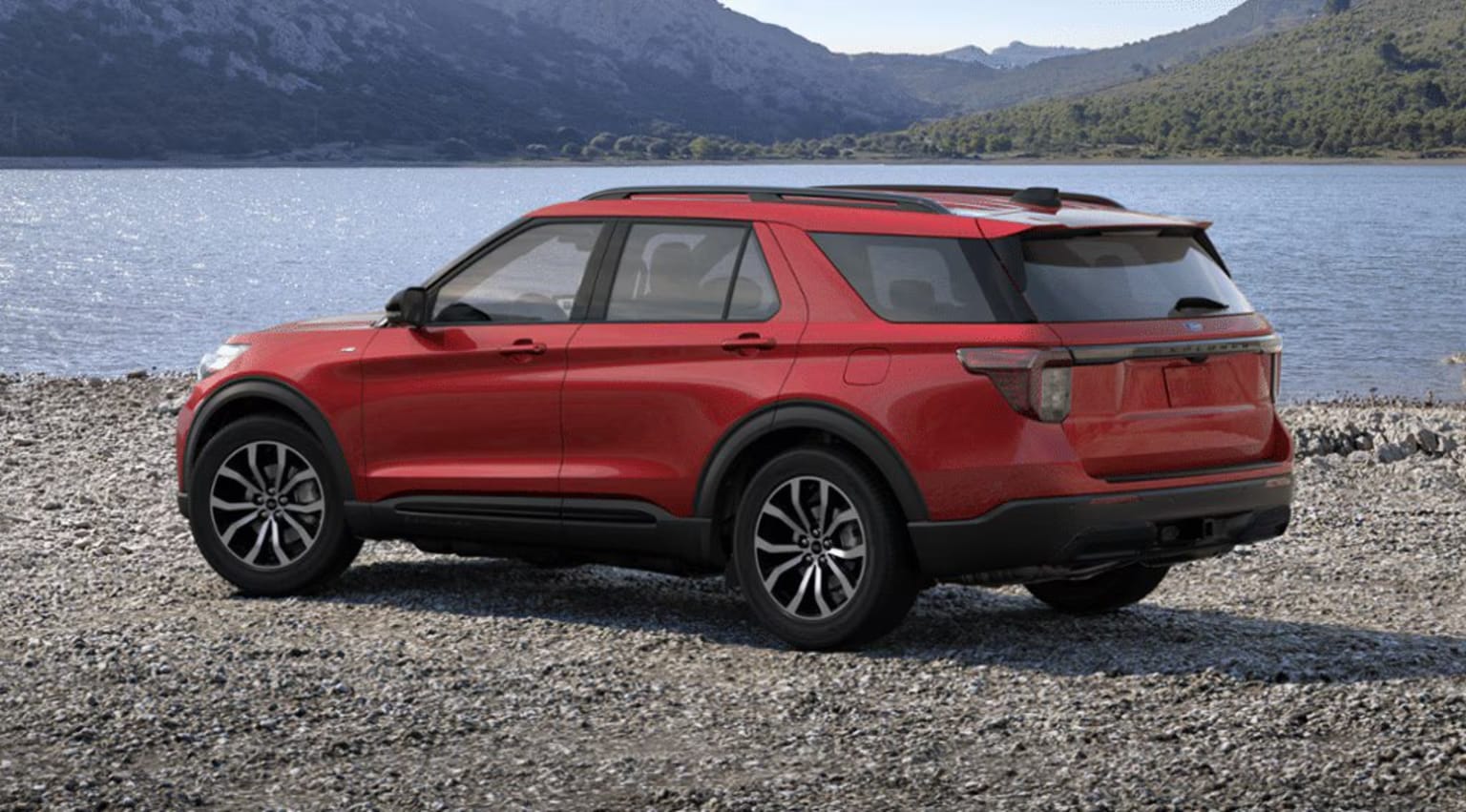 2025 Ford Explorer Exterior Color Option Rapid Red Metallic Tinted Clearcoat parked by a scenic lake with mountains in the background.