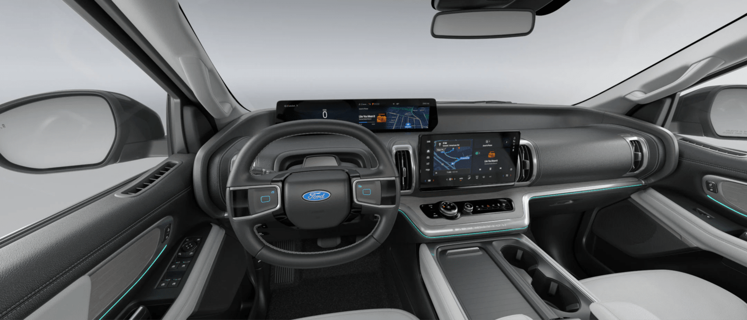 A modern car interior with a large touchscreen display, digital dashboard, steering wheel, and center console.