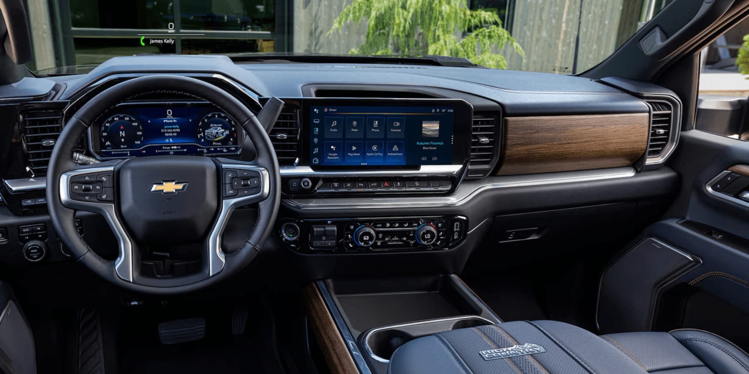 Interior of a modern, high-end vehicle with a sleek dashboard design, large touchscreen display, various controls, and a wood-grain accent.