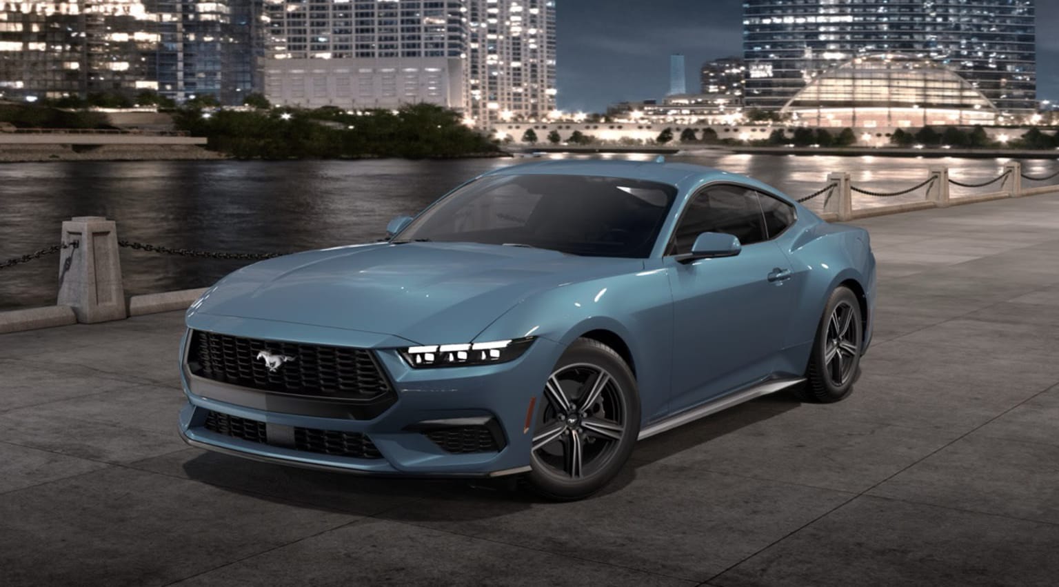 A sleek, light blue sports car parked on a riverfront promenade, with a backdrop of towering skyscrapers and a nighttime cityscape.