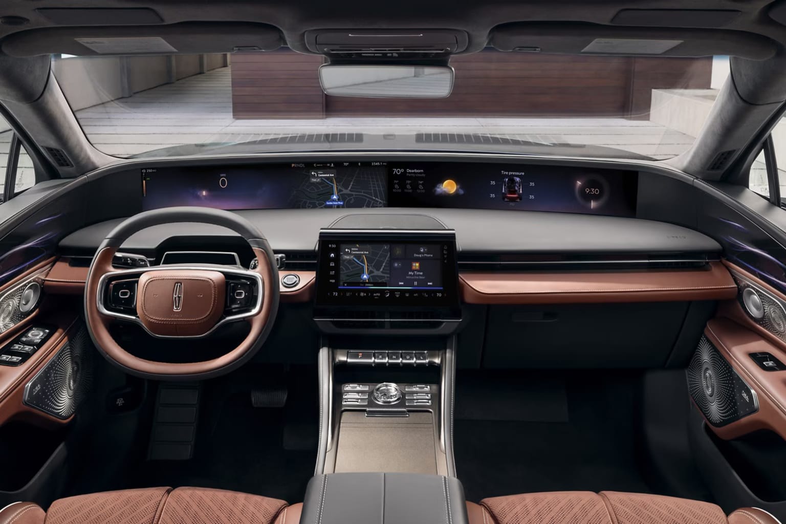 Interior of a modern, high-tech vehicle with a sleek dashboard, a large central display, and various controls and buttons. The background appears to be a dimly lit indoor setting, possibly a showroom or a garage.