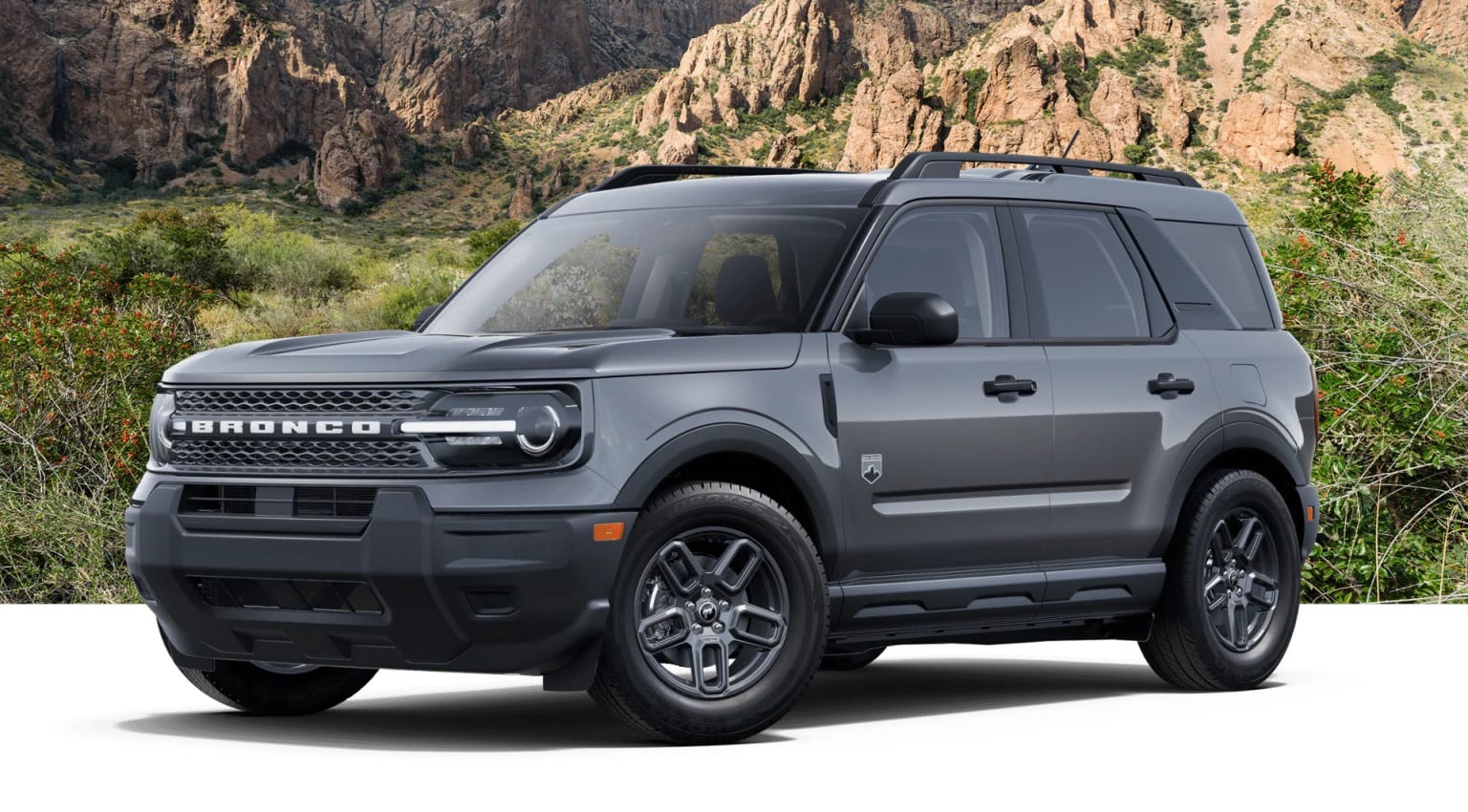A rugged and off-road-ready SUV stands in the foreground, its bold design complemented by the dramatic mountainous landscape in the background.