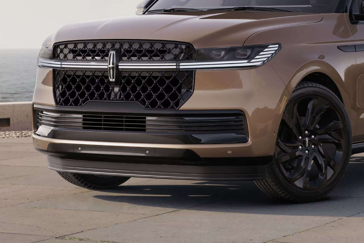 A sleek and modern-looking SUV with a distinctive grille and black accents, parked on a paved surface against a plain background.