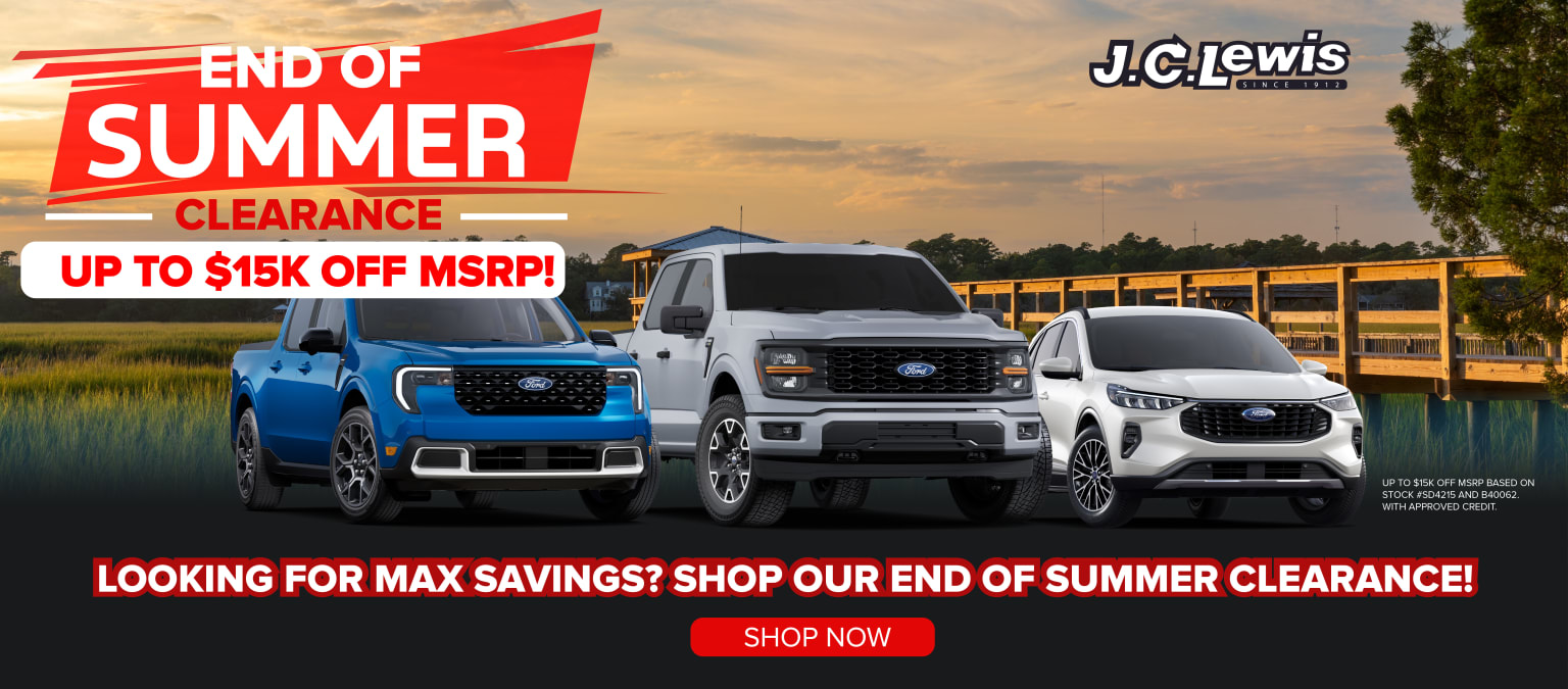 The image shows a variety of trucks and SUVs against a scenic sunset landscape. A banner promotes the dealership's end-of-season sales event.