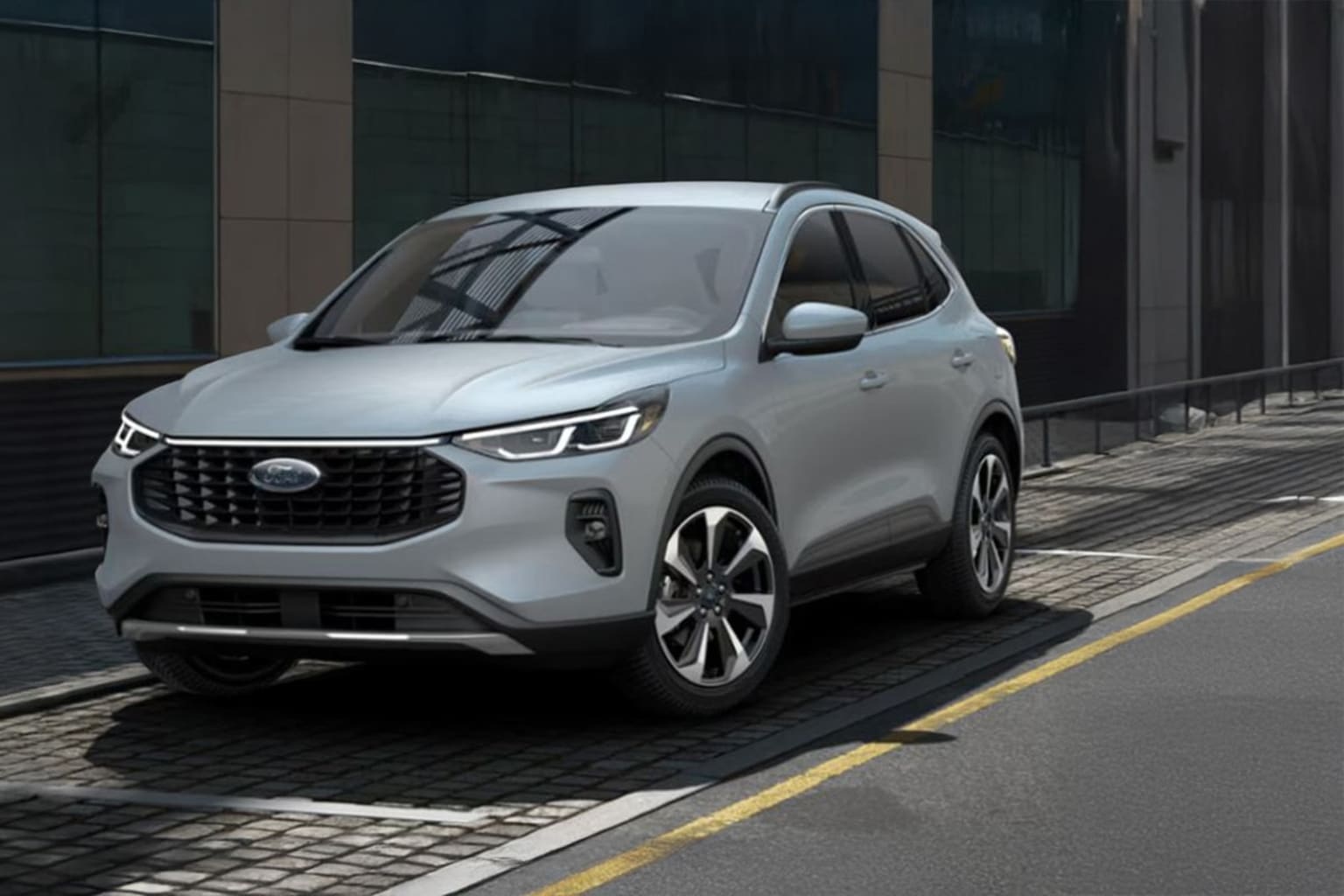 A sleek, modern-looking SUV with a silver exterior parked in front of a glass-walled building.