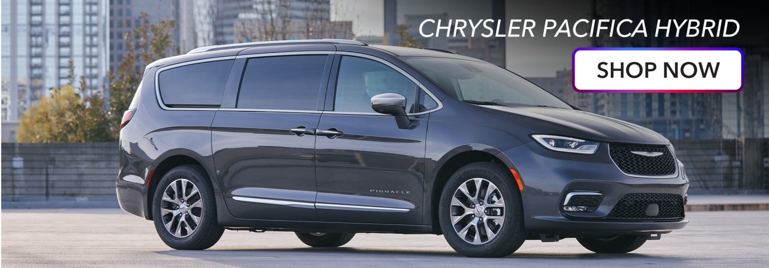 a gray chrysler pacifica parked in front of a building with the words chrysler pacifica on it's side