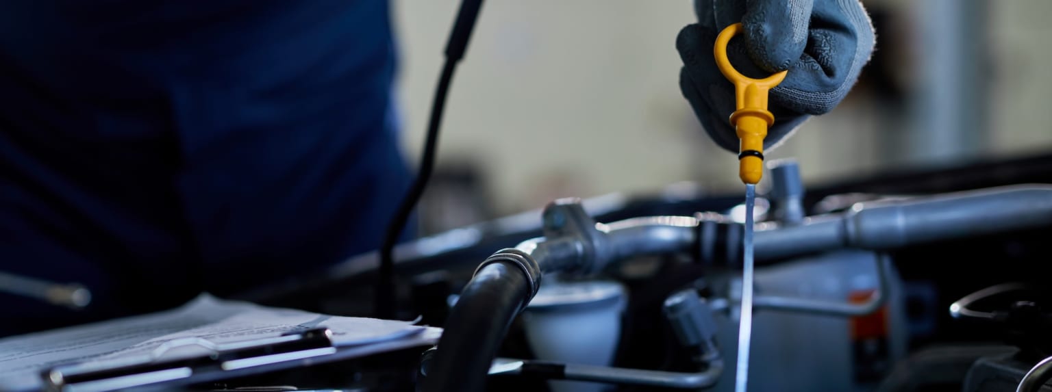 Close-up image of a screwdriver being used on a mechanical device in a workshop or garage setting