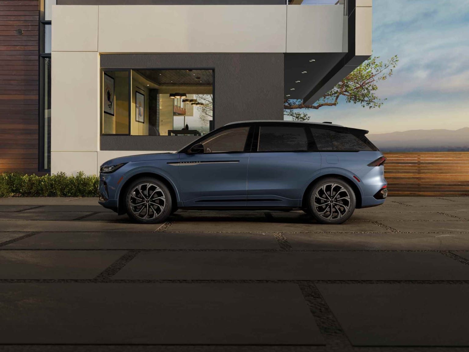 An SUV parked in front of a modern building with minimalist design and landscaping.