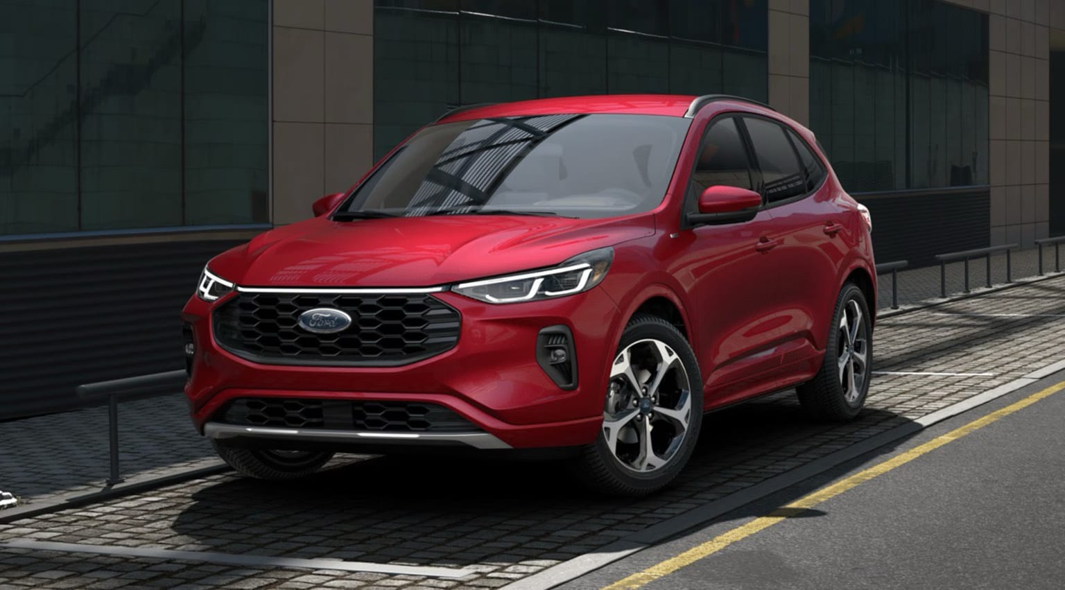 A bright red, sporty-looking SUV parked in front of a modern glass and steel building, its sleek design and bold color standing out against the urban backdrop.