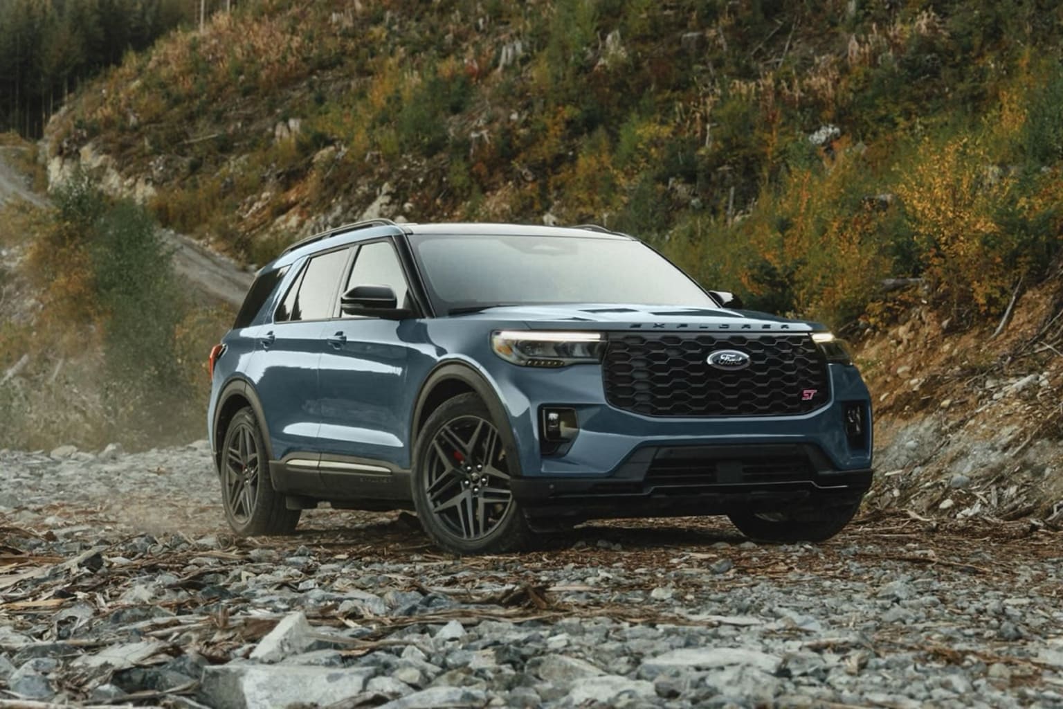 Off-road SUV in a rugged mountain terrain with lush vegetation.