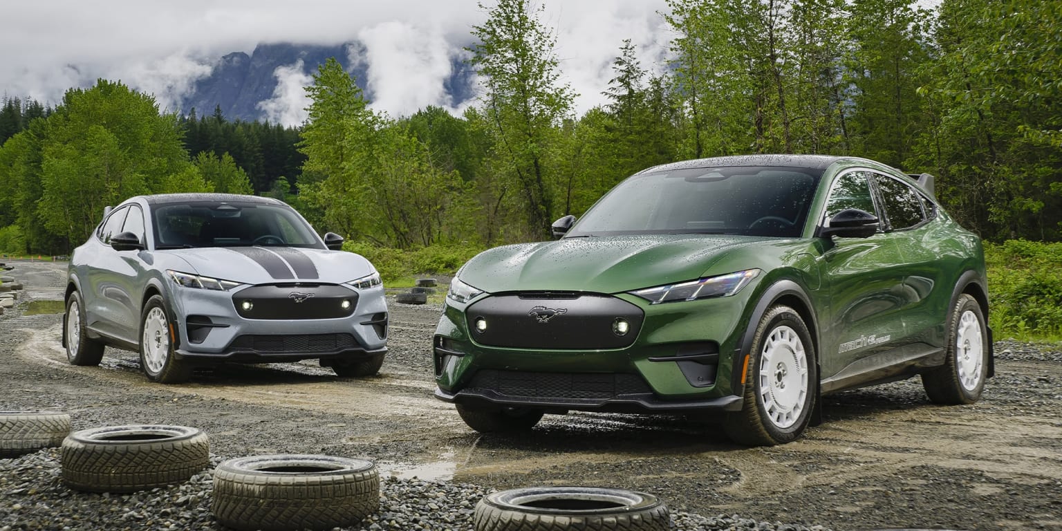 Sleek, modern SUVs in a vibrant green color parked on a dirt road surrounded by lush, verdant trees and a misty, mountainous backdrop.
