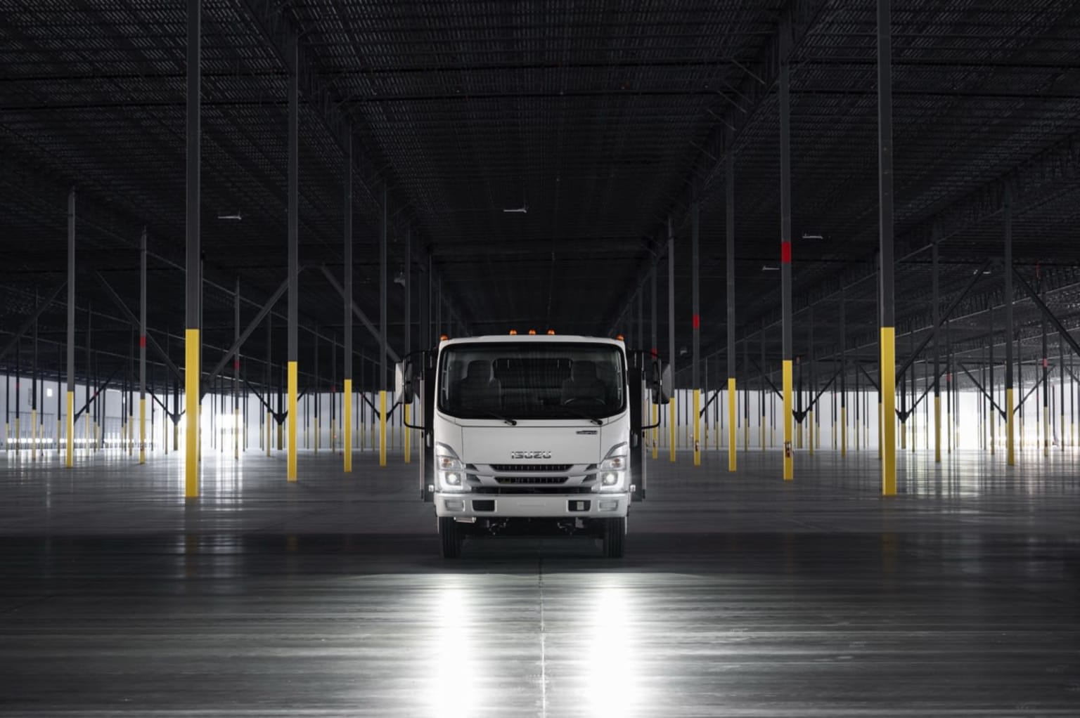 A large delivery truck in a warehouse with safety markers.