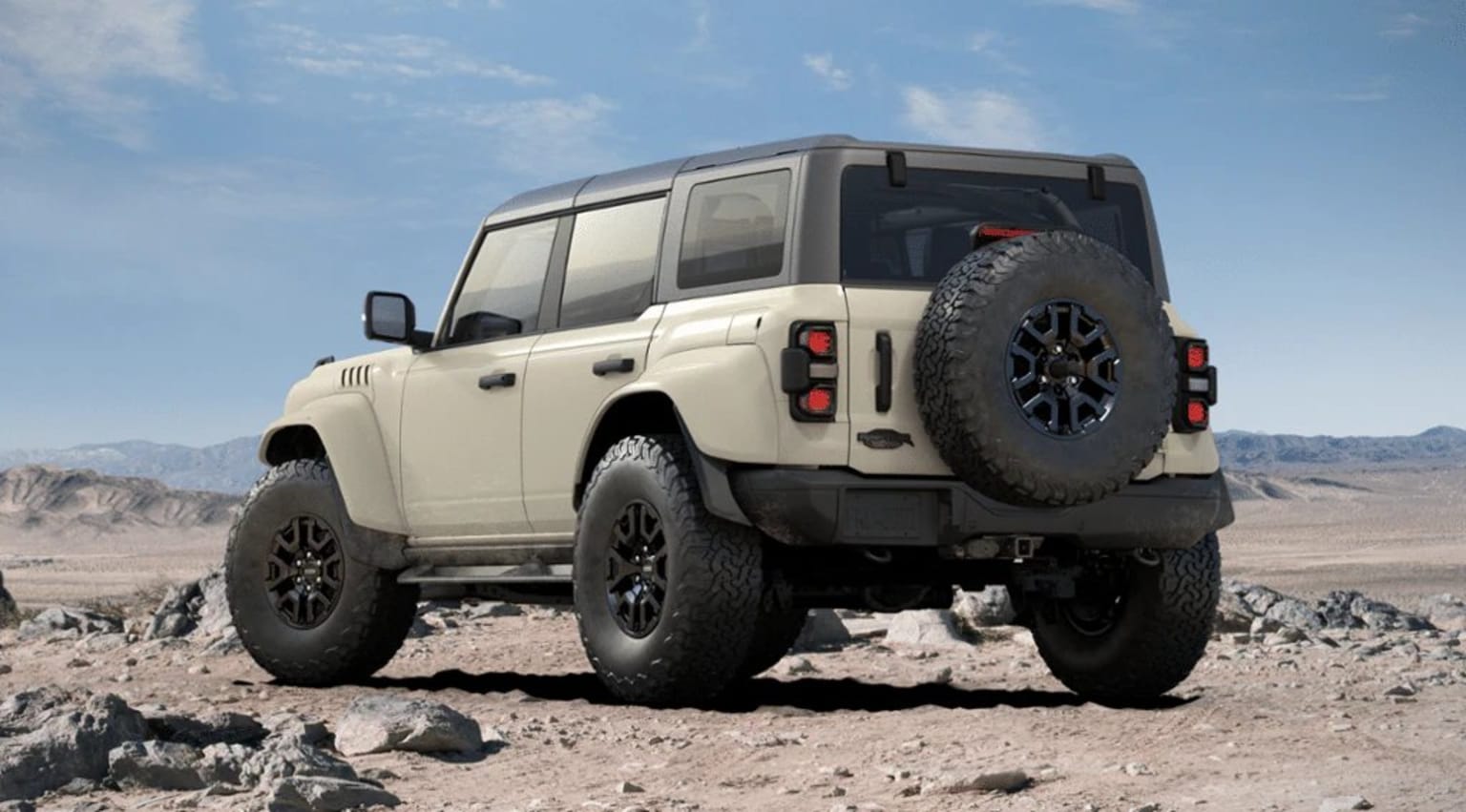Off-road vehicle in a desert landscape with rocky terrain and clear blue sky.