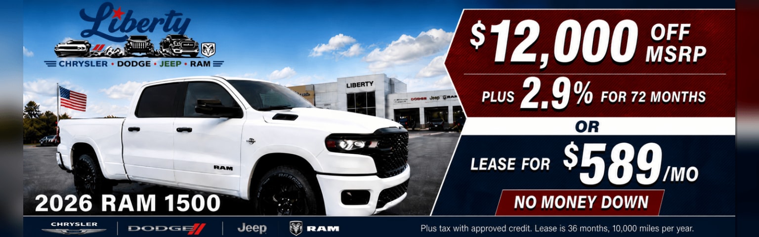 A white 2026 truck is parked in front of a dealership with a large advertisement.