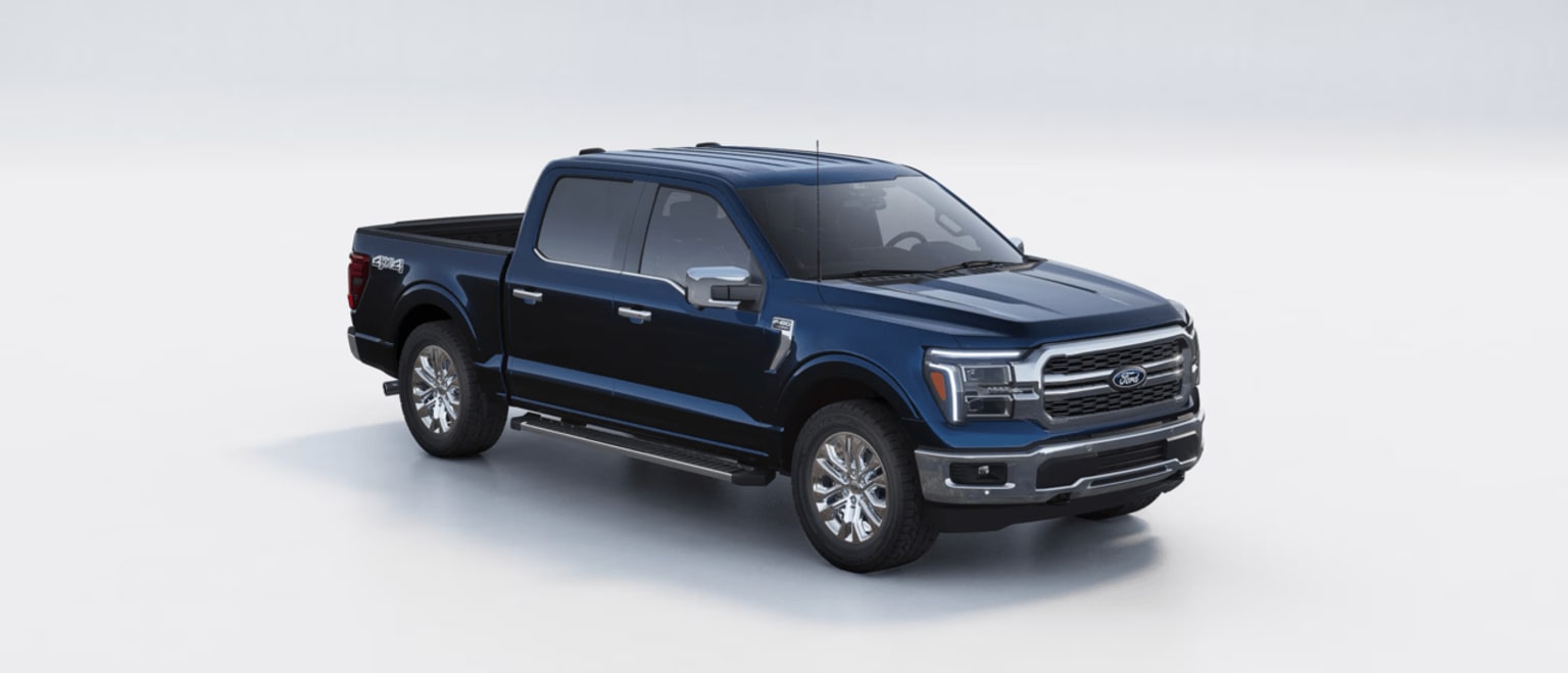 A dark blue, large pickup truck with a cargo bed in the foreground, set against a plain, light-colored background.