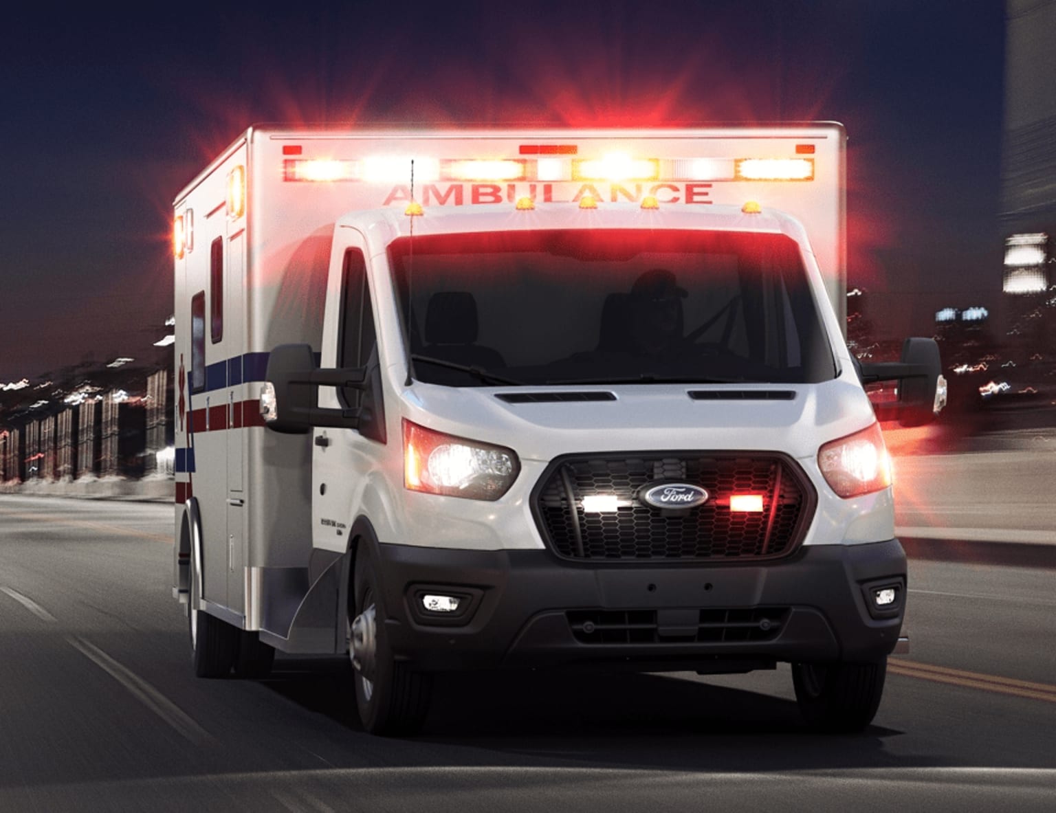 an ambulance driving down a city street at night with its lights on and emergency lights on the side of the truck