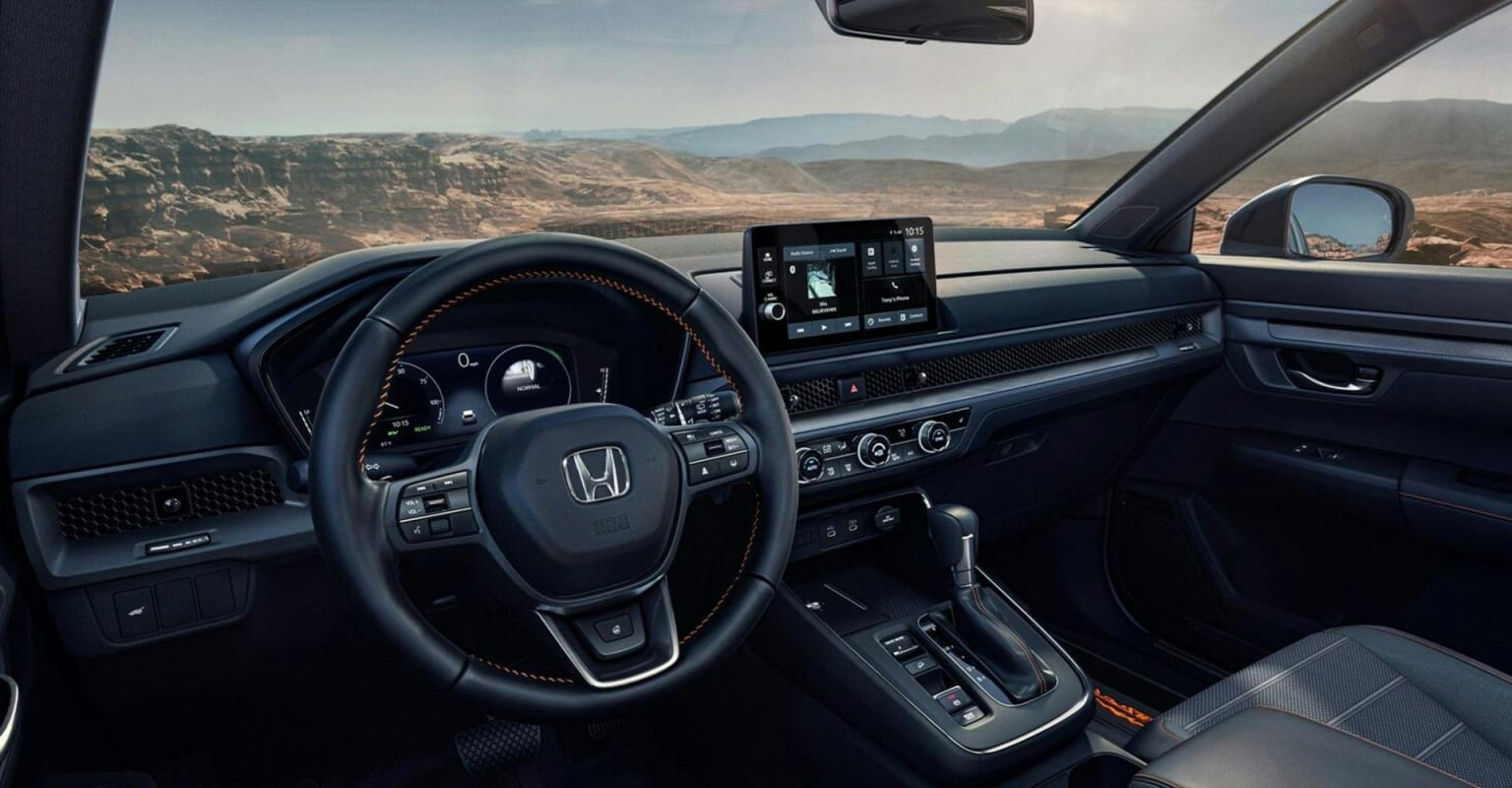 Modern dashboard with a touchscreen display in car interior with a mountainous landscape visible through windows in the background