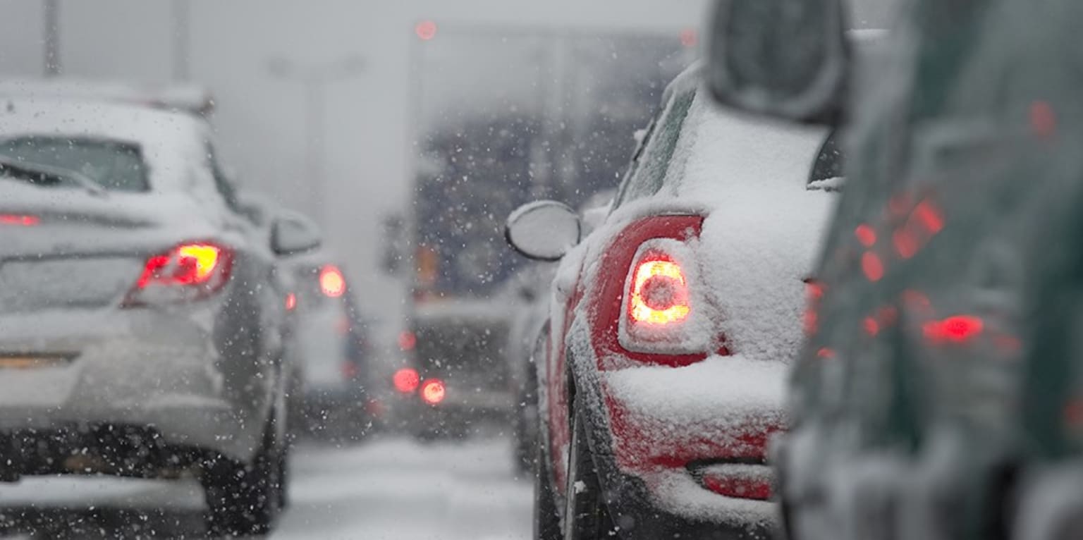 a bunch of cars that are covered in some kind of white stuff on a snowy day in the city