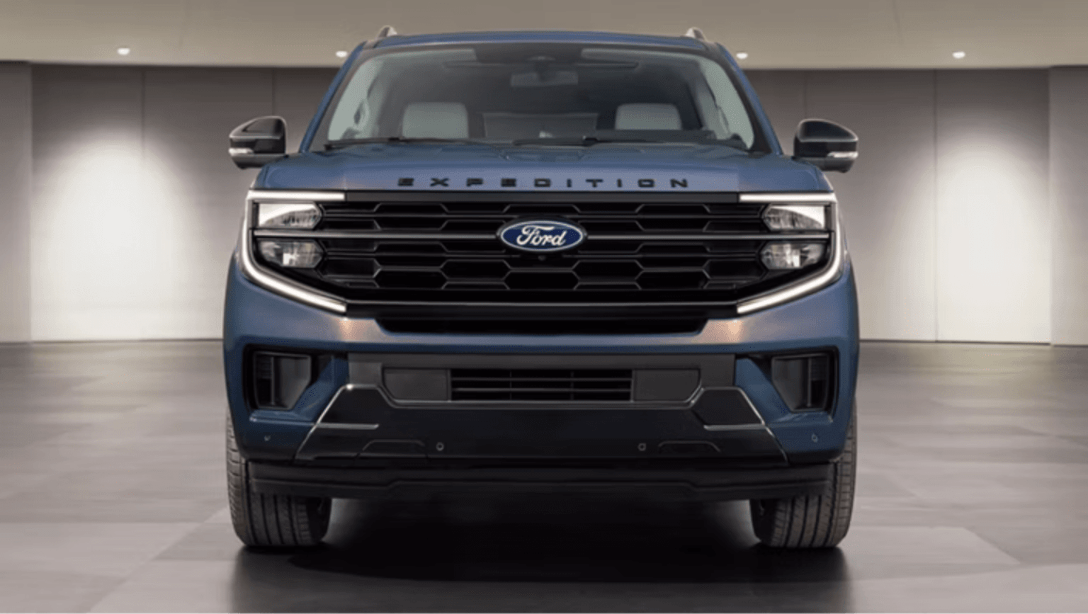 A large blue SUV centered in the foreground against a minimalist, brightly lit white studio background.
