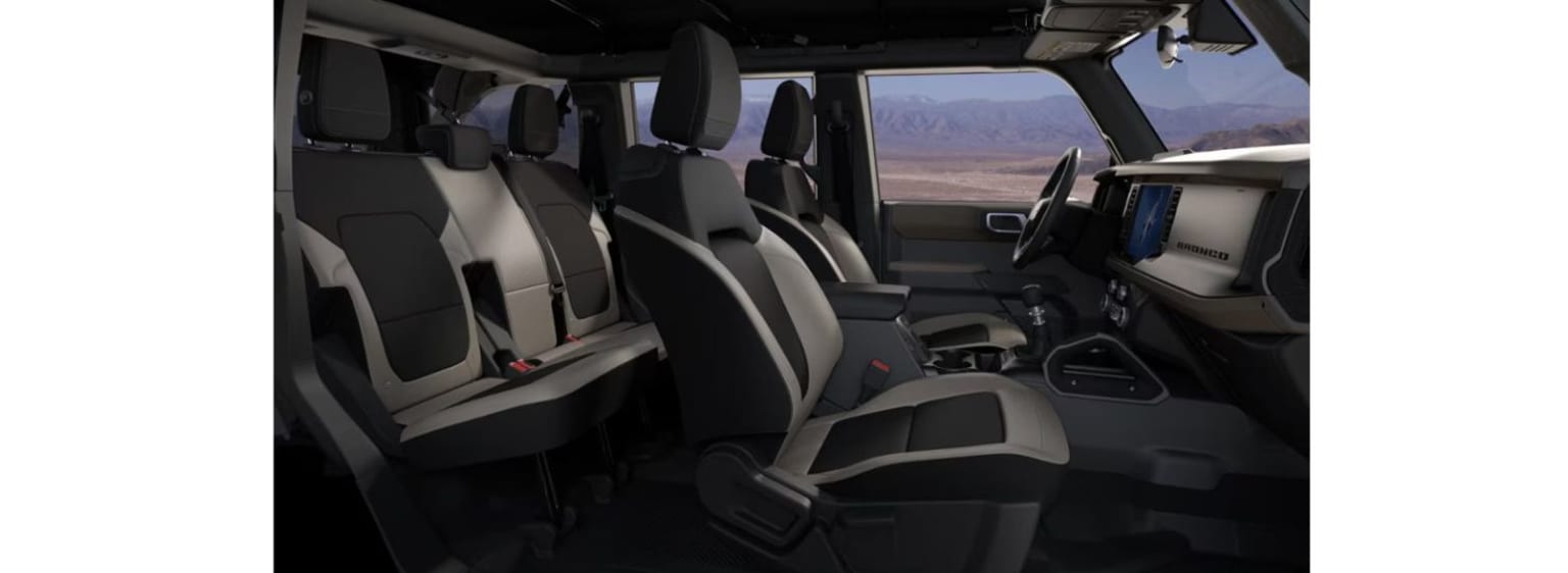 Image of a spacious vehicle interior with multiple rows of seats and a scenic desert landscape visible through the windows.