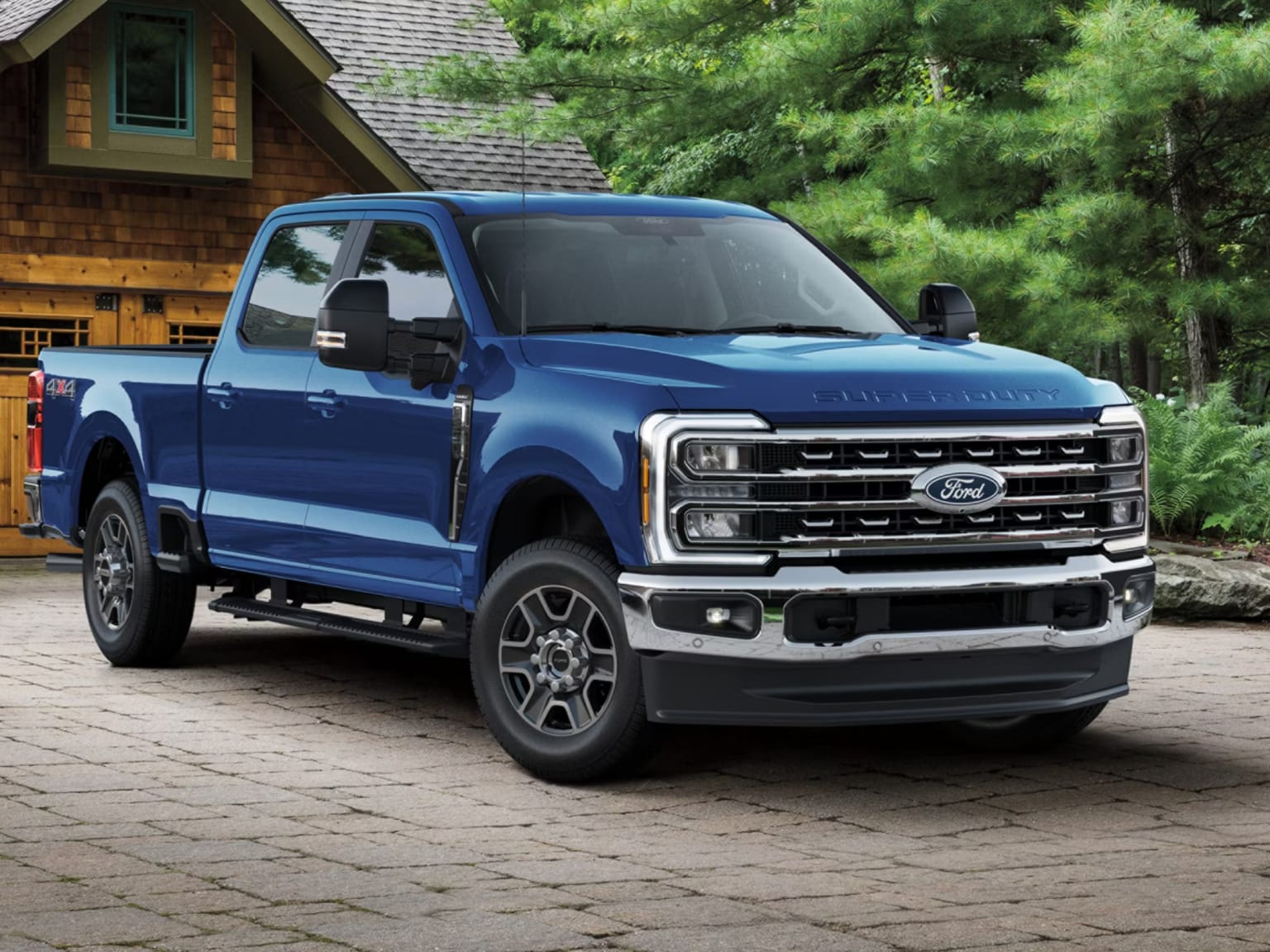 Blue pickup truck parked in front of house and trees