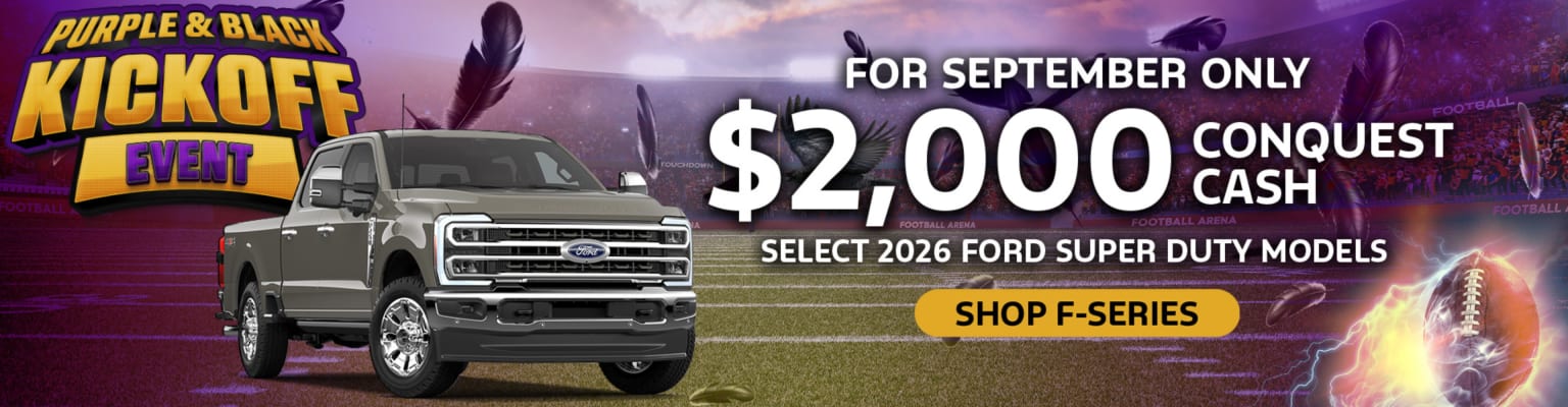 A gray heavy-duty truck is featured in the foreground with a "Purple & Black Kickoff Event" banner and a promotional offer, set against a blurred background of a stadium with purple and black accents.