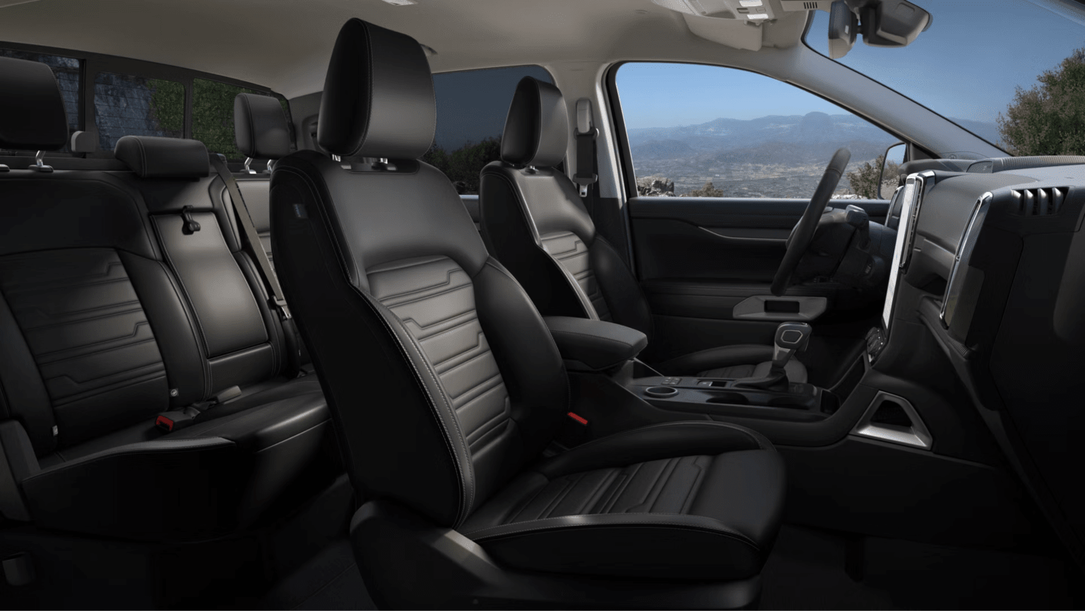 Black leather car seats with a mountainous landscape visible through the windows in the background.