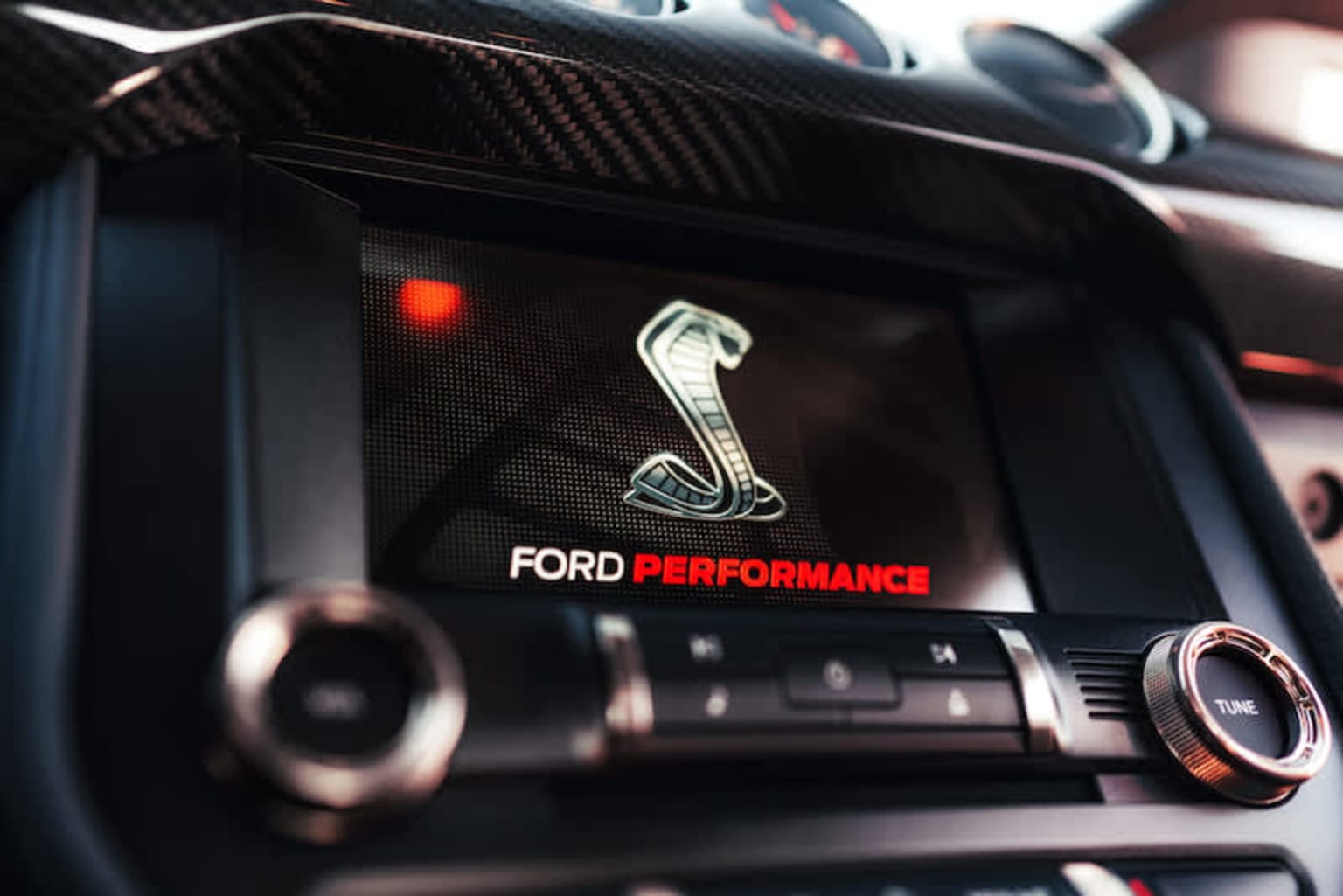 a close up of a car radio with a ford performance sticker on the front of the display screen