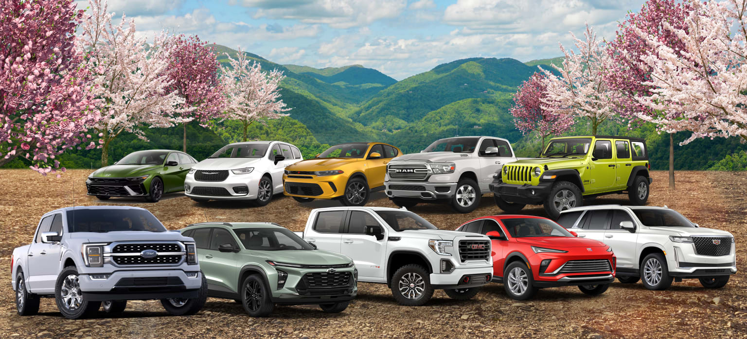 Off-road vehicles on mountain terrain with cherry blossom trees.