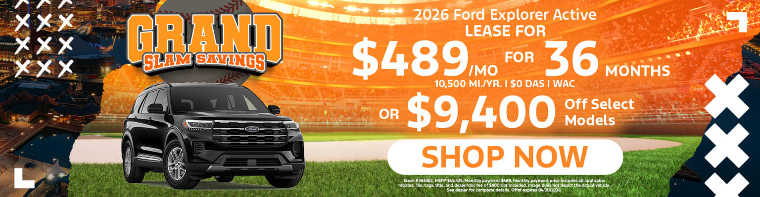 The image shows a black SUV in the foreground, with a large advertisement in the background.