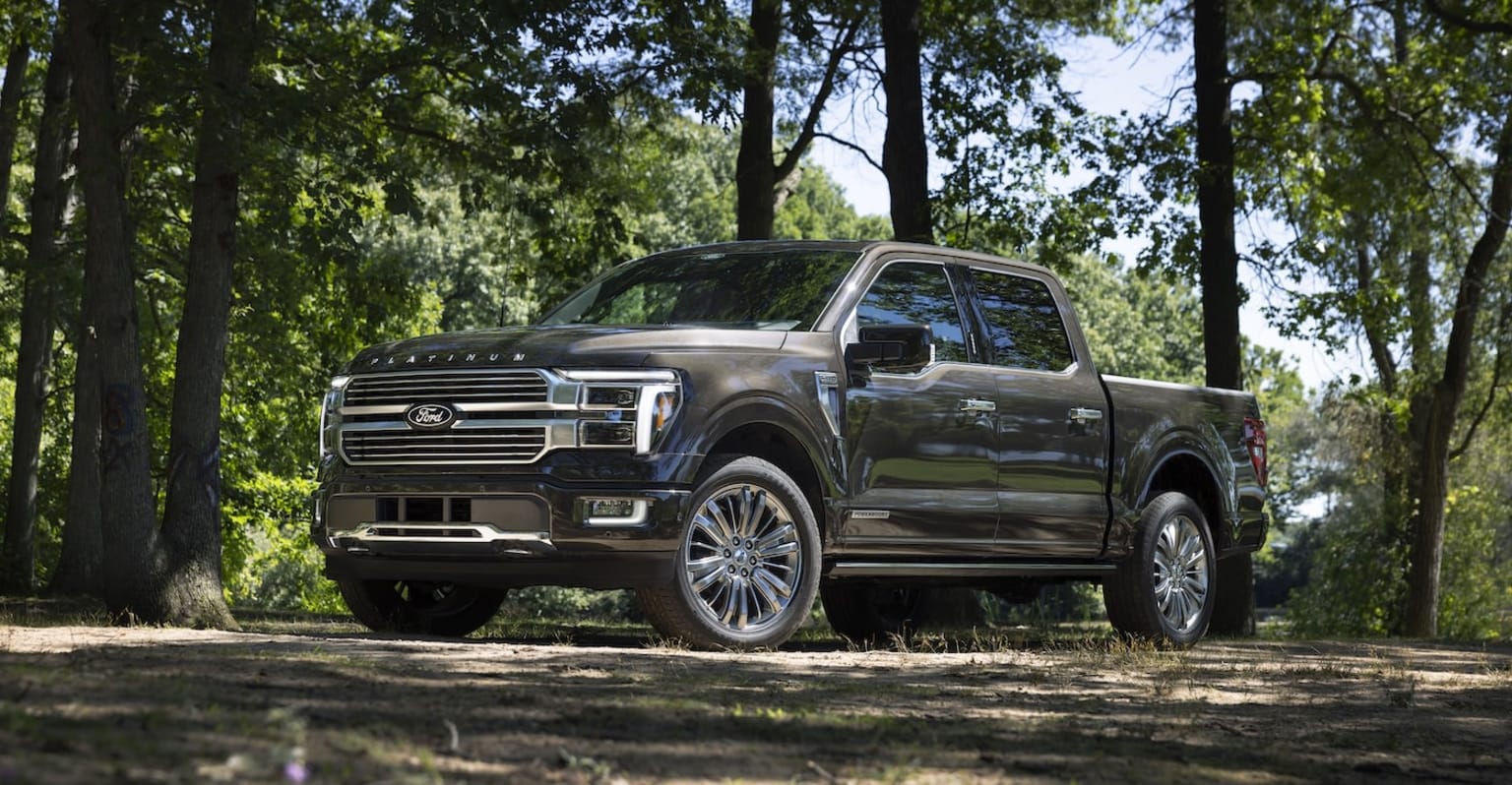 Luxurious pickup truck in a lush, forested setting with sleek design and chrome accents.