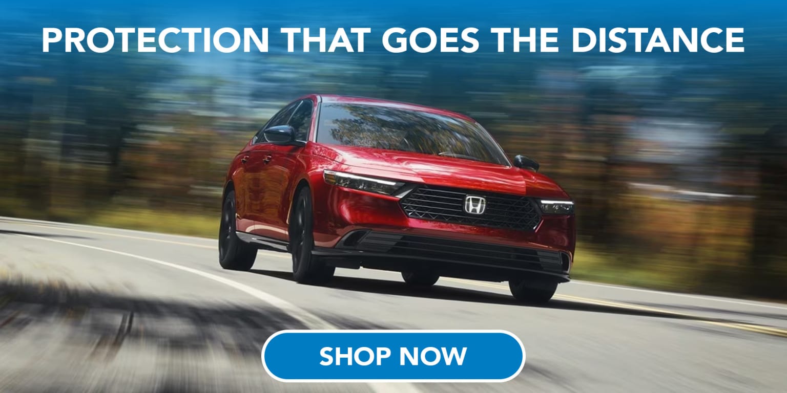 A red car driving on a road with blurred trees in the background, and a "Shop Now" button in the foreground.