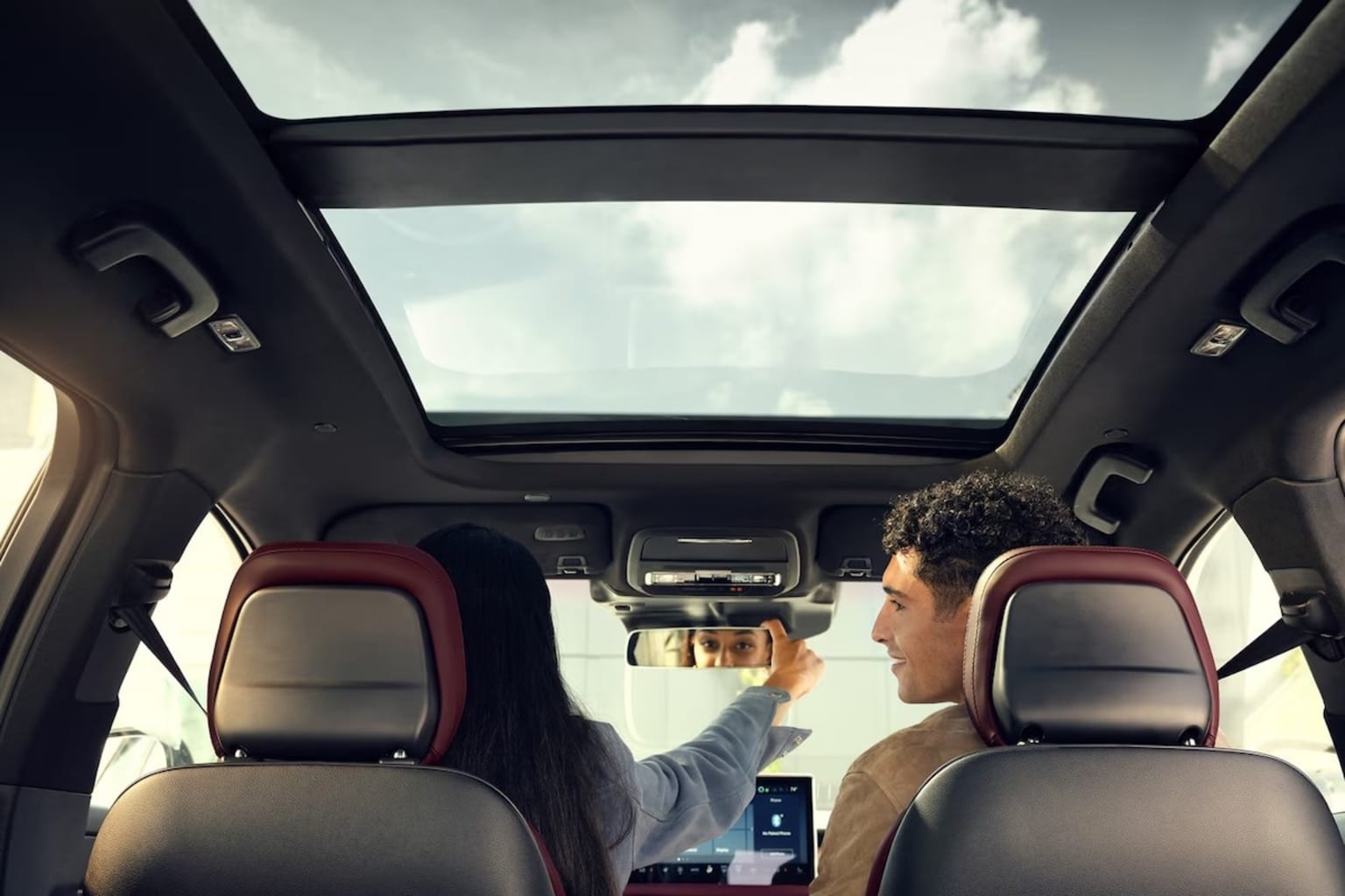 2025 Lincoln Corsair autodimming rearview mirror being adjusted by a women with a man in the passenger seat