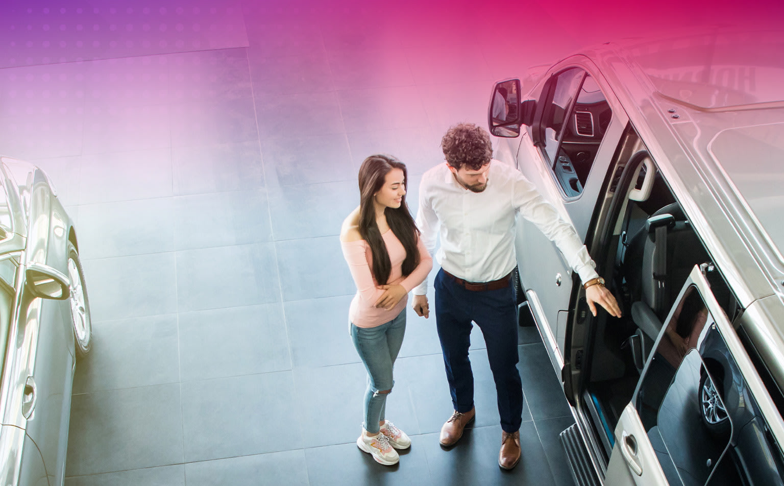 Two people, a man and a woman, are standing together in a brightly lit, colorful environment with abstract shapes and patterns in the background.