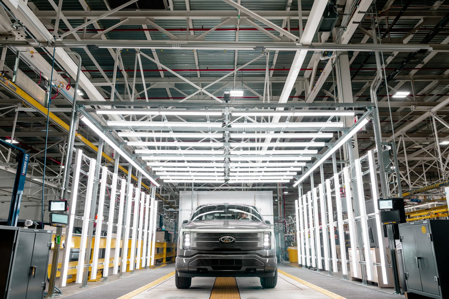 a car is parked inside of a large building with a lot of steel beams on the sides of the building