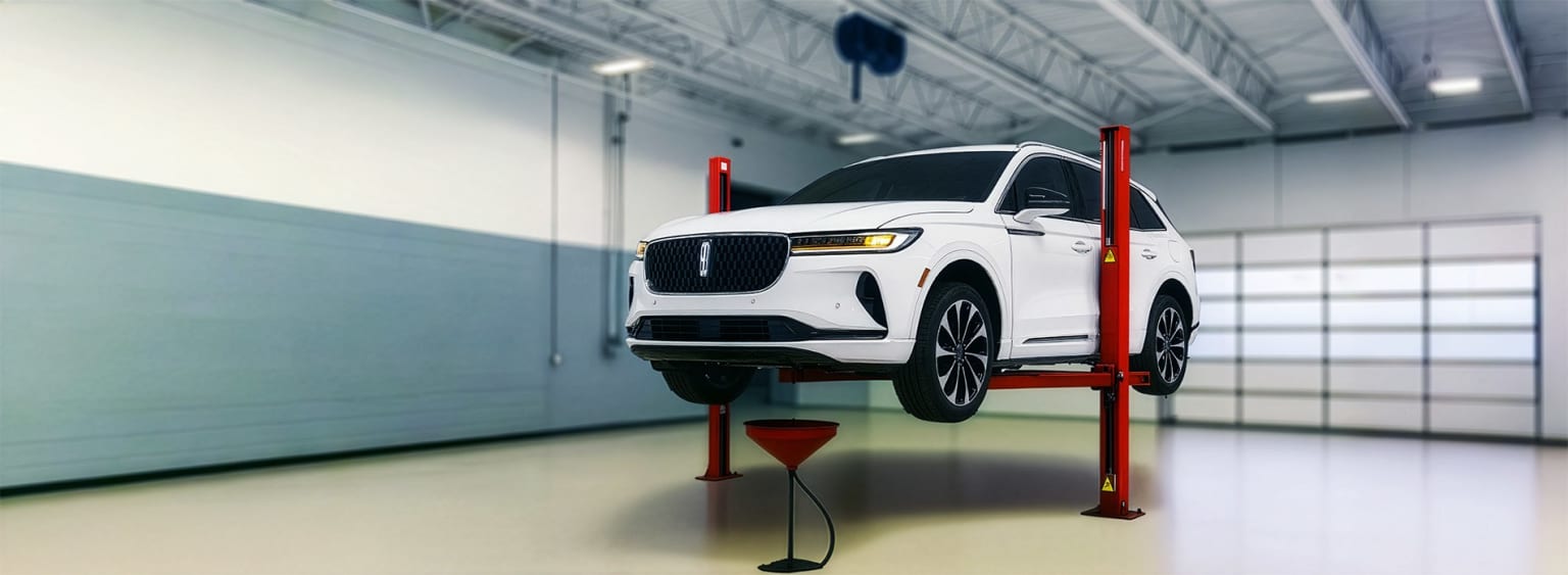 Lincoln Maintenance Service being done on a Nautilus on a lift with the oil being drained in a service bay.