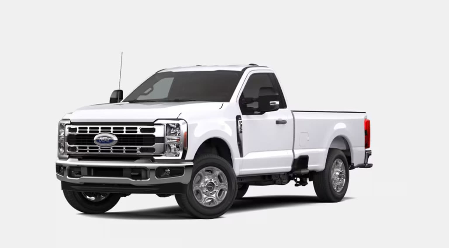 A white Ford pickup truck with a rugged, off-road appearance stands prominently in the foreground against a plain white background.