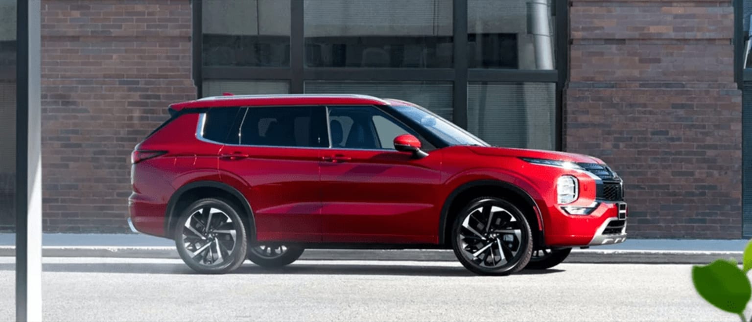 a red suv is parked in front of a brick building with a green arrow pointing to the side of the vehicle