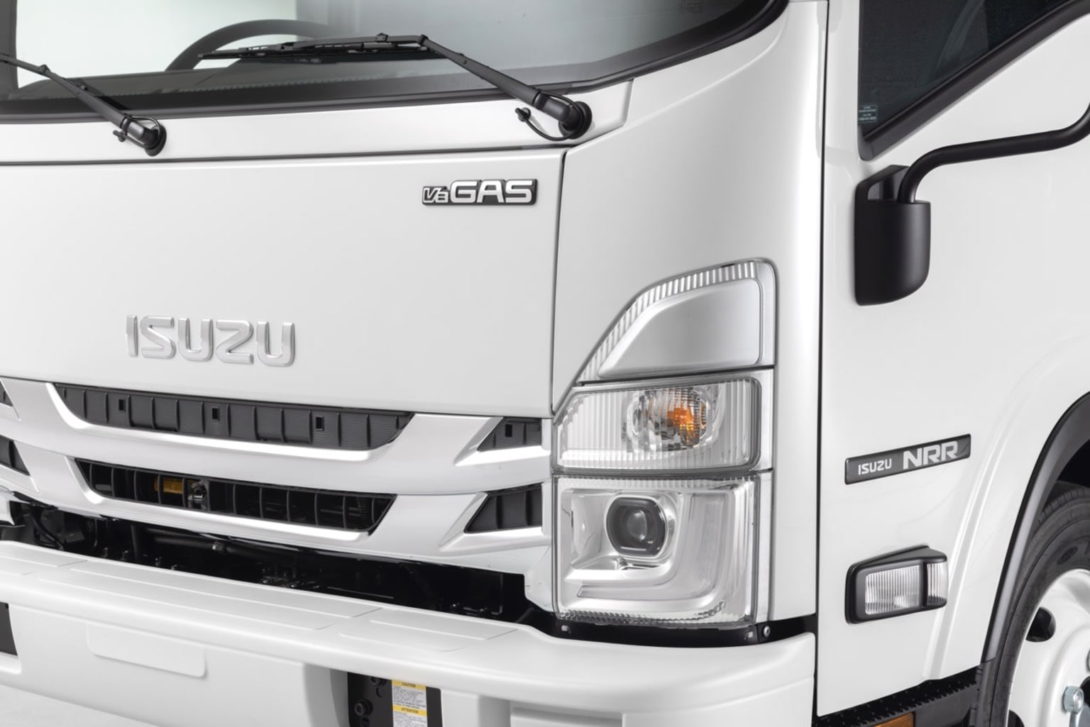 A white truck with various features and details visible, including the front grille, headlights, and side mirrors, against a plain background.