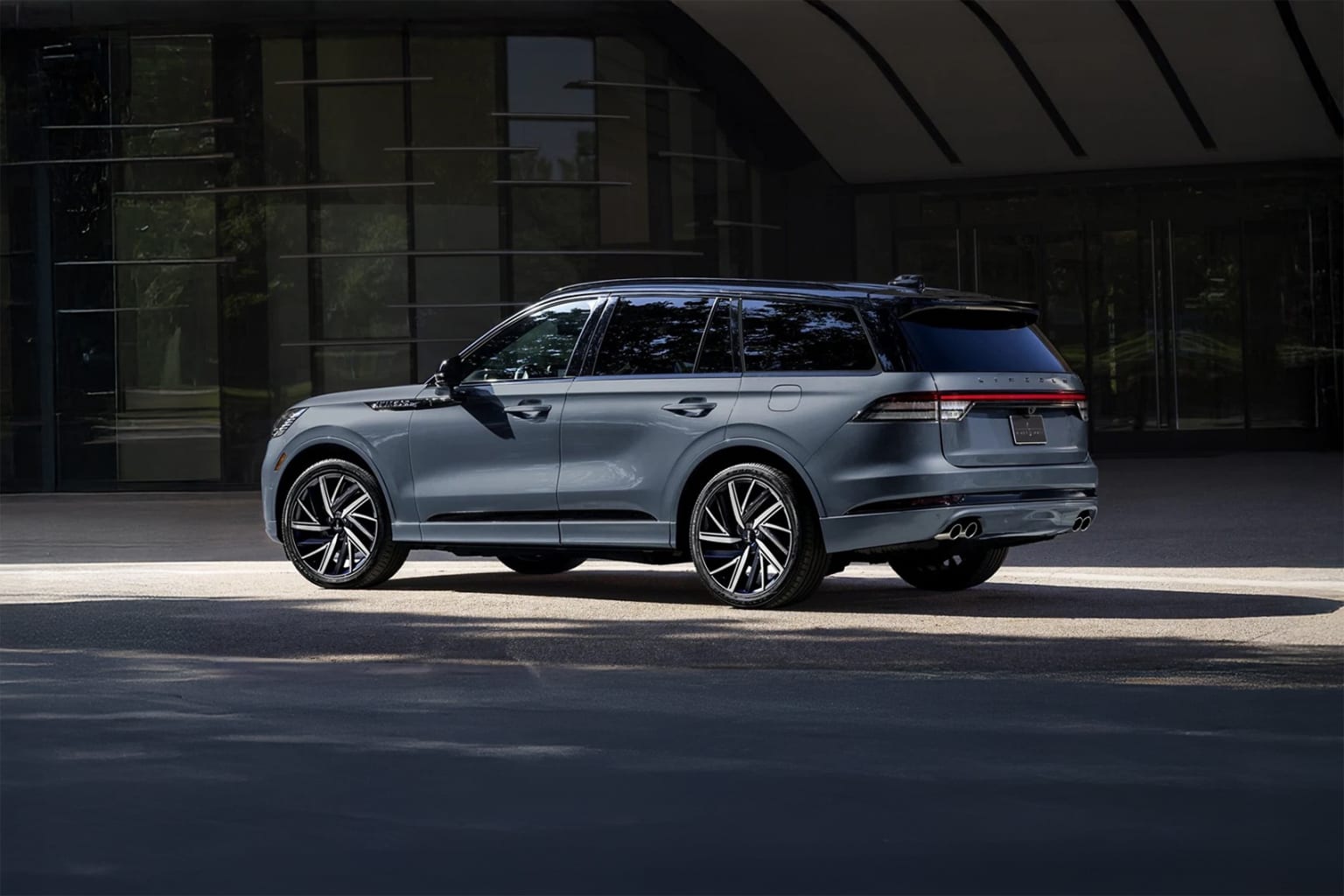 Silver SUV parked in front of modern building.