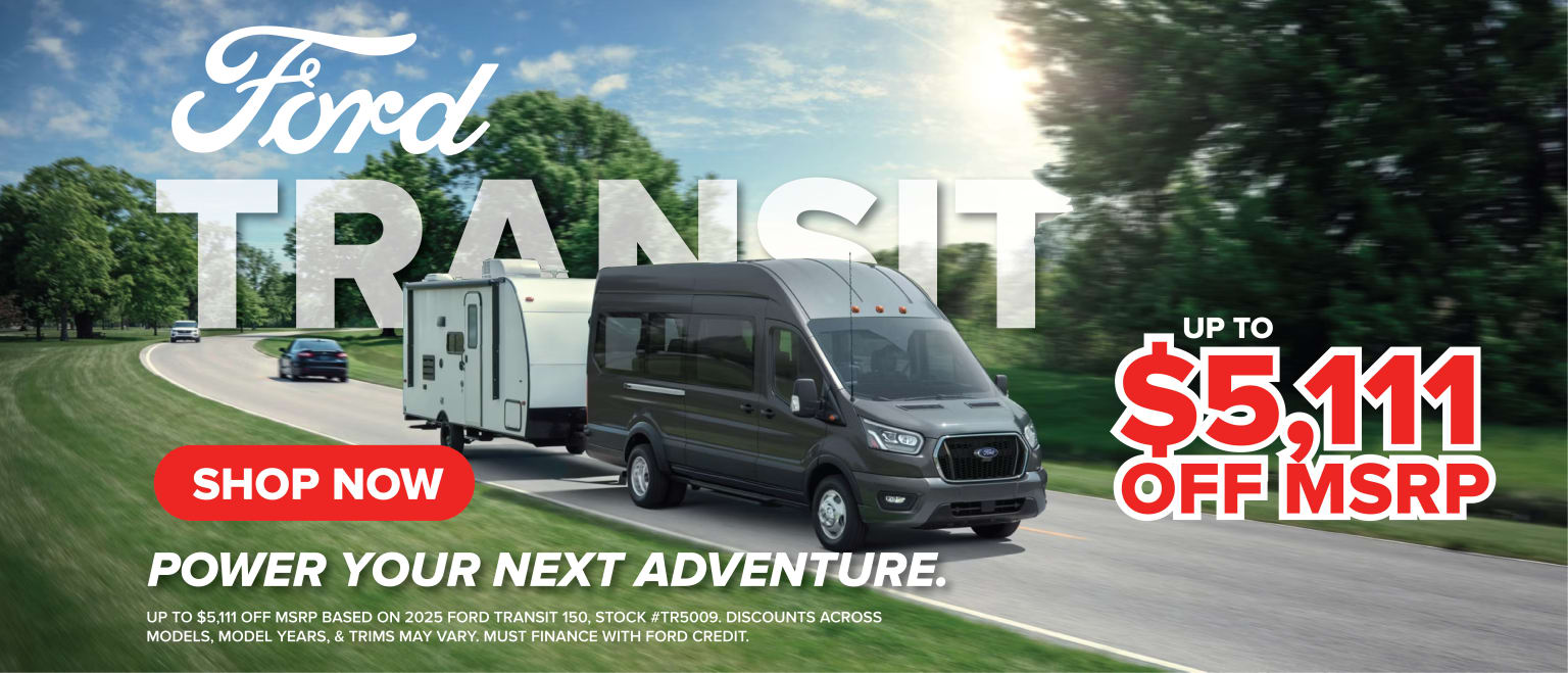 A van is parked in the foreground, with a countryside landscape in the background, featuring trees and a cloudy sky.