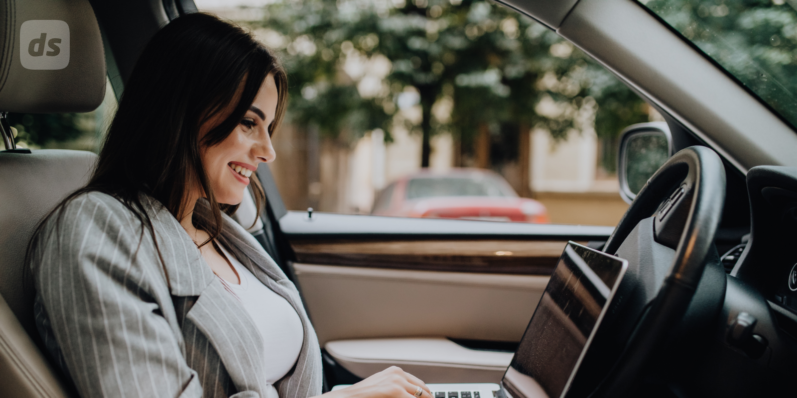 Girl in car using a laptop