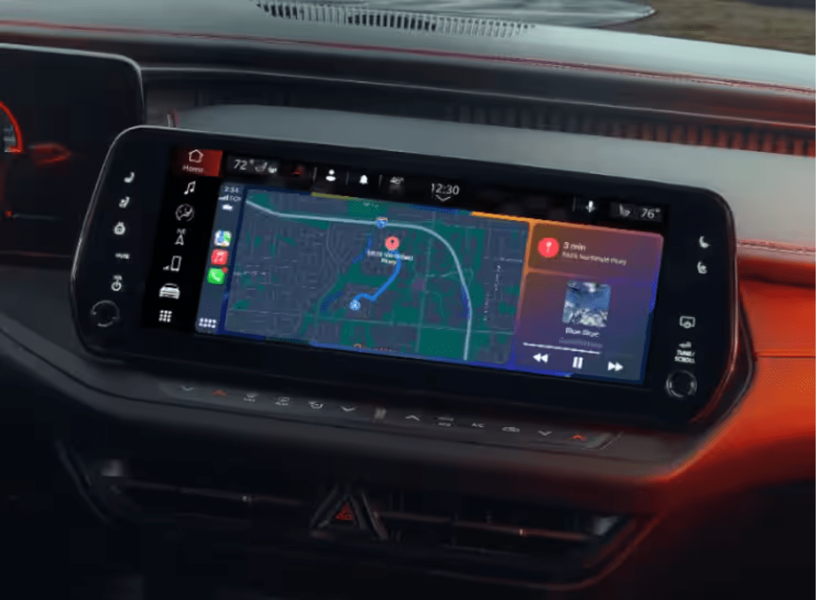 Digital infotainment screen displaying a map and music player in modern car interior with red-stitched dashboard in the background.