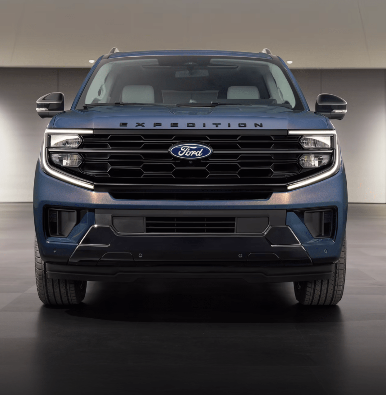 A blue SUV is front and center against a plain, light-colored background.