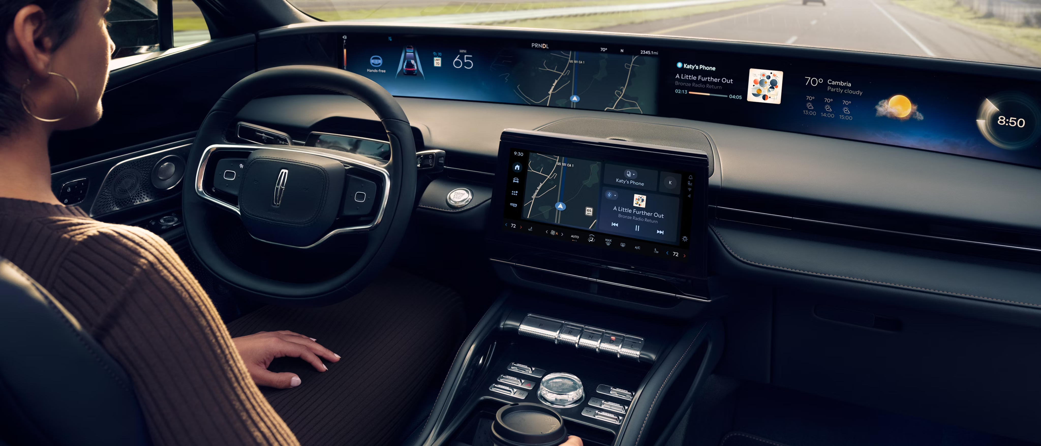 A person sits in the driver's seat of a car with a digital dashboard, looking out the windshield with a blurred road ahead.